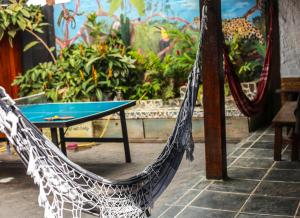 Samblumba Hostel Trindade في ترينيداد: وجود أرجوحة للجلوس بجانب طاولة في الفناء