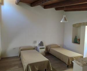 two beds in a room with white walls at LA CASETTA 6058 in Conversano