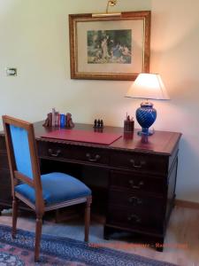 a wooden desk with a lamp and a chair at Rose cottage in Pontrieux