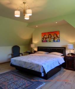 a bedroom with a bed and a painting on the wall at Rose cottage in Pontrieux
