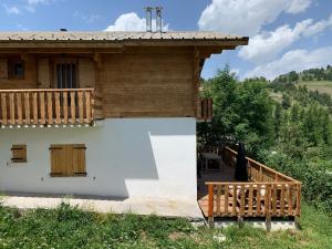 une maison avec une terrasse couverte en bois et une terrasse dans l'établissement Bas de Chalet l'Entasse n°9, à Valberg