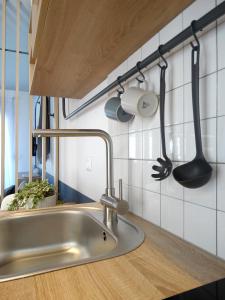 un lavandino con utensili da cucina appesi al muro di Voula Seaside Apartments a Kallithea