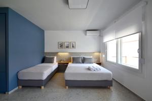1 dormitorio con 2 camas y ventana en Voula Seaside Apartments, en Kallithea Halkidikis