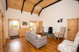 uma sala de estar com um sofá e uma cadeira em Mary's Cosy Cottage on the Wild Atlantic Way em Galway