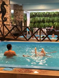 a group of people swimming in a swimming pool at Hotel Rieger in Balneário Camboriú