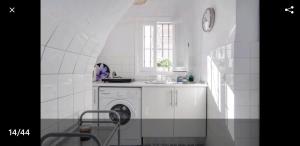 a white kitchen with a washing machine in it at Precioso y acogedor ático old town in Marbella