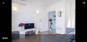 ein weißes Wohnzimmer mit einem TV und einem Sofa in der Unterkunft Precioso y acogedor ático old town in Marbella