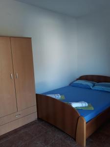a bedroom with a bed and a cabinet at Apartmani Stojanović in Sutomore