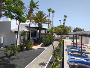 una fila de tumbonas junto a una piscina en Bungalow DALAI - Pool view- Good wifi, en Puerto del Carmen