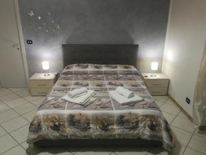 カターニアにあるCasa Desirèのベッドルーム1室(大型ベッド1台、ナイトスタンド2台付)