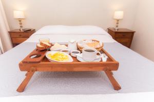 Una bandeja con alimentos para el desayuno y café sobre una cama. en Hotel Amalfi - ex Santisimo, en Viña del Mar