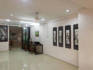 a room with a table and paintings on the wall at Sweethome for travelers in Seremban