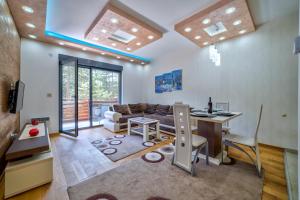 a living room with a couch and a table at LUX apartman u vili Pekovic in Zlatibor