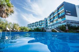 une piscine en face d'un bâtiment dans l'établissement Cordelia Resort, à Seogwipo