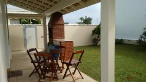 a patio with a table and chairs on a patio at CASA - FRENTE PARA O MAR in Itanhaém