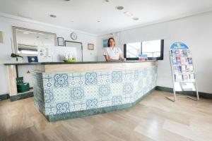 a woman standing at a counter in a room at Apartamentos Moraña in Puerto del Carmen +97 photos