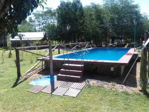 a swimming pool with a swing and stairs in a yard at Cabañas don graziano in Azul