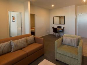 a living room filled with furniture and a couch at Ramada Suites by Wyndham Christchurch City in Christchurch