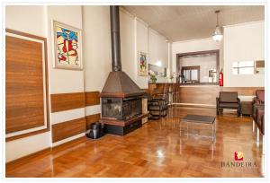 a living room with a woodburning stove in a room at Bandeira Hotel in Caxias do Sul