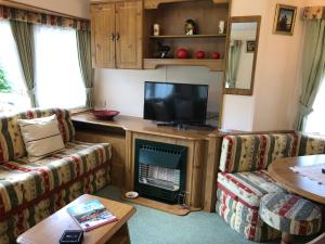 a living room with two couches and a television at 61 Glenfinart Caravan Park in Dunoon