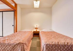 
a bedroom with a bed and a dresser at 斑尾観光ホテル in Iiyama
