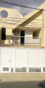 een huis met witte garagedeuren in een straat bij Casa aconchegante próxima a Basílica! in Aparecida