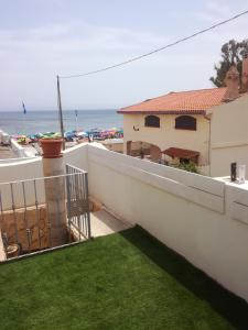 a balcony with green grass and a view of the ocean at Domo Sant'Antioco in SantʼAntìoco