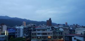 a city skyline with buildings and mountains in the background at Toucheng Homestay in Toucheng