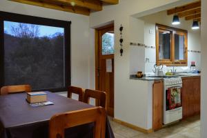a kitchen with a table with chairs and a counter top at Cabañas & Apart Ruta 63 in Villa Meliquina +42 photos