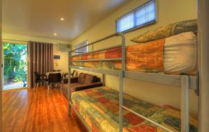 a room with two bunk beds and a living room at Kookaburra Holiday Park in Cardwell +36 photos