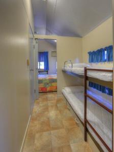 a room with two bunk beds and a hallway at Kookaburra Holiday Park in Cardwell