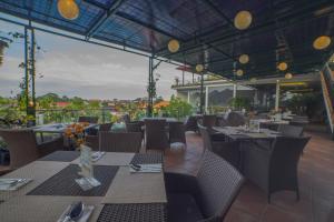 a restaurant with tables and chairs with a view at Grand Kesambi Resort and Villas in Kerobokan