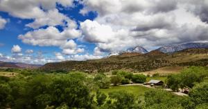 uma vista para um vale com montanhas e árvores em Canyon Of The Ancients Guest Ranch em Cortez