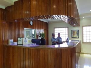 two men standing at a counter in an office at Lae City Hotel in Lae