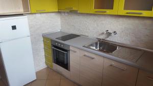 a kitchen with a sink and a white refrigerator at Dom Shtakovi in Pomorie