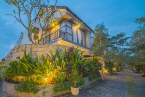 a house with lights on the side of it at Grand Kesambi Resort and Villas in Kerobokan