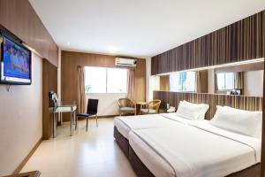 Postel nebo postele na pokoji v ubytování Golden City Rayong Hotel