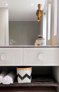 een badkamer met een wastafel en een spiegel bij Meno House - Adults Only in Gili Meno