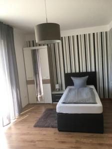 um quarto com uma cama e uma luz pendente em Pension Sonntag Ferienwohnungen em Ingolstadt