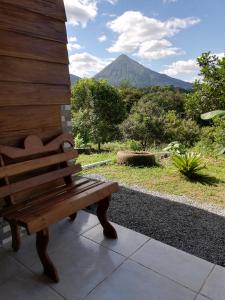 un banco sentado en un porche con una montaña al fondo en Cabaña Rural el Mirador, en Fortuna