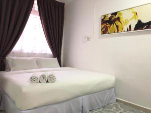 sypialnia z łóżkiem z dwoma ręcznikami w obiekcie Terengganu Guest House w mieście Kuala Terengganu