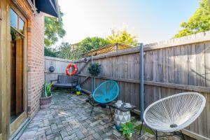 a patio with two chairs and a fence at 5 Stars Sydney City & Airport Retreat in Sydney