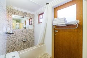 a bathroom with a shower and a wooden door at 5 Stars Sydney City & Airport Retreat in Sydney