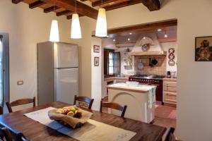 パニカーレにあるAgriturismo Poggio del Peroのキッチン(木製テーブル付)、キッチン(冷蔵庫付)