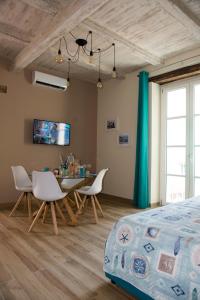 a bedroom with a bed and a table and chairs at RESIDENZA MARIA ANTONIETTA - 50 METRI DAL MARE in Pizzo