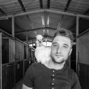 człowiek trzymający kurczaka na głowie w obiekcie Agriturismo Poggio del Pero w mieście Panicale