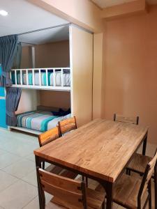 una sala da pranzo con tavolo, sedie e letto a castello di Oasis Hostel & Bar a Karon Beach