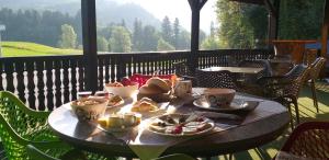 einen Tisch mit Teller mit Speisen und Tassen auf einem Balkon in der Unterkunft Guesthouse Urša in Preddvor