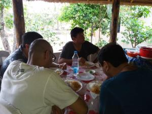 a group of people sitting around a table eating food at Solitary Nook in Gosāba +27 photos