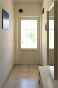 a bathroom with a door and a tiled floor at Apartment Rose in Korčula +22 photos